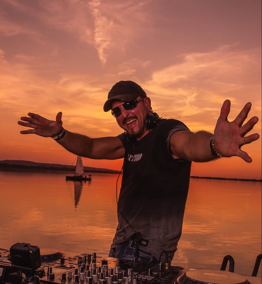 DJ mixing music with a sunset in the background