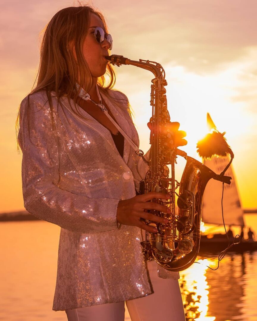 Female saxophone player with a sunset in the background