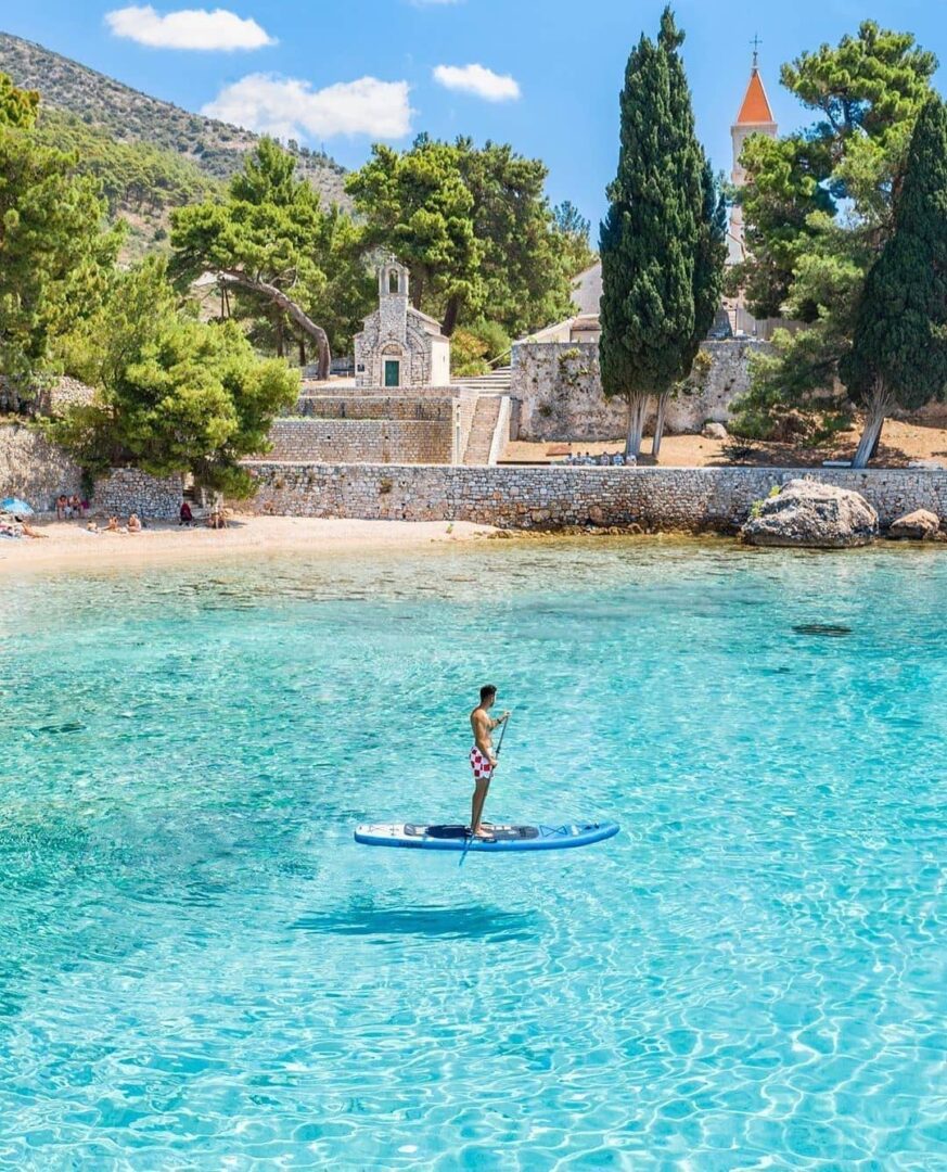 Yacht Charter in Brač paddleboarding near a beach