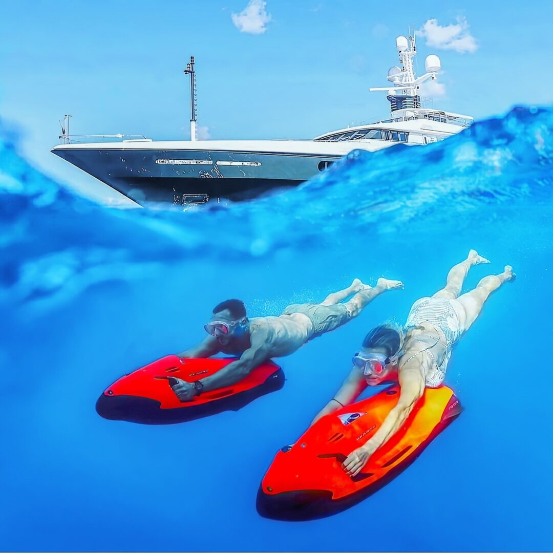 two yacht charter guests riding a seabob underwater