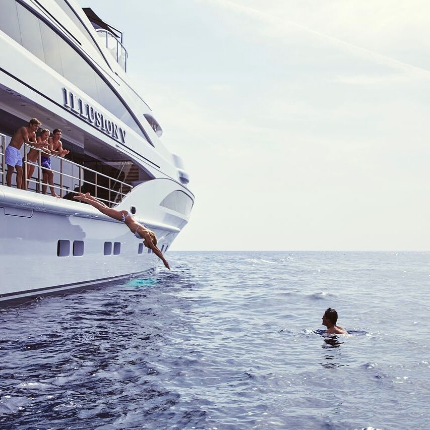 girl jumping in the sea from a yacht