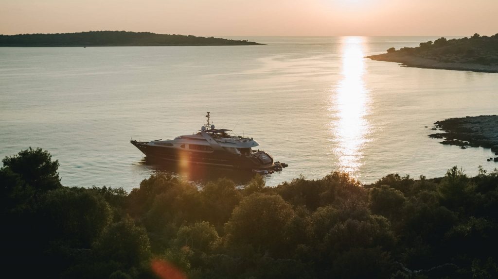 one blue yacht charter at sunset