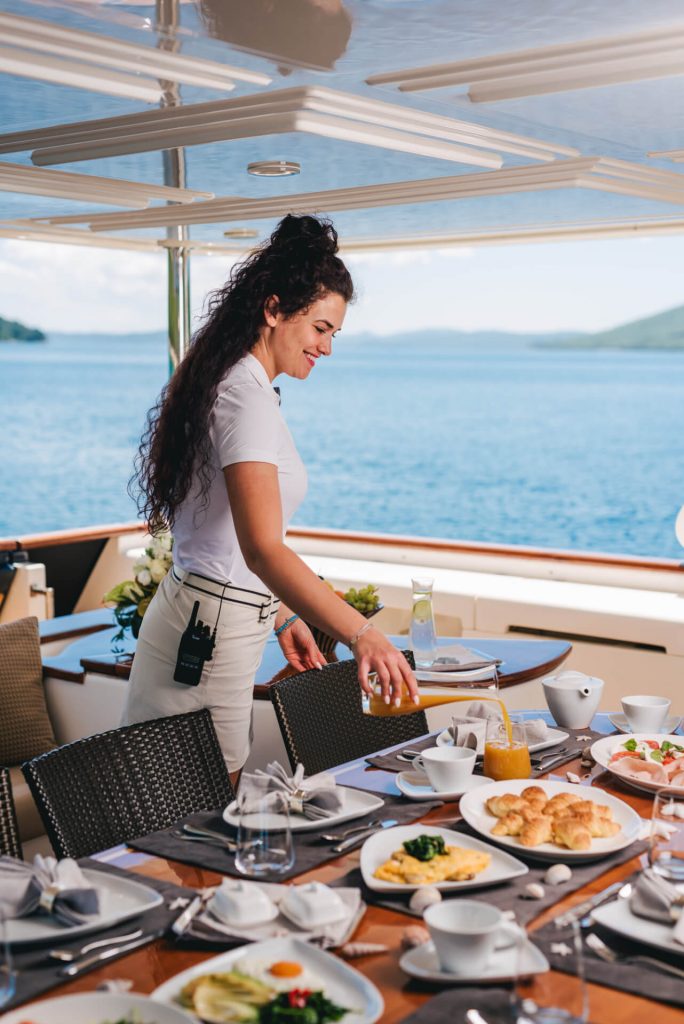 klobuk yacht charter stewardess pouring juice