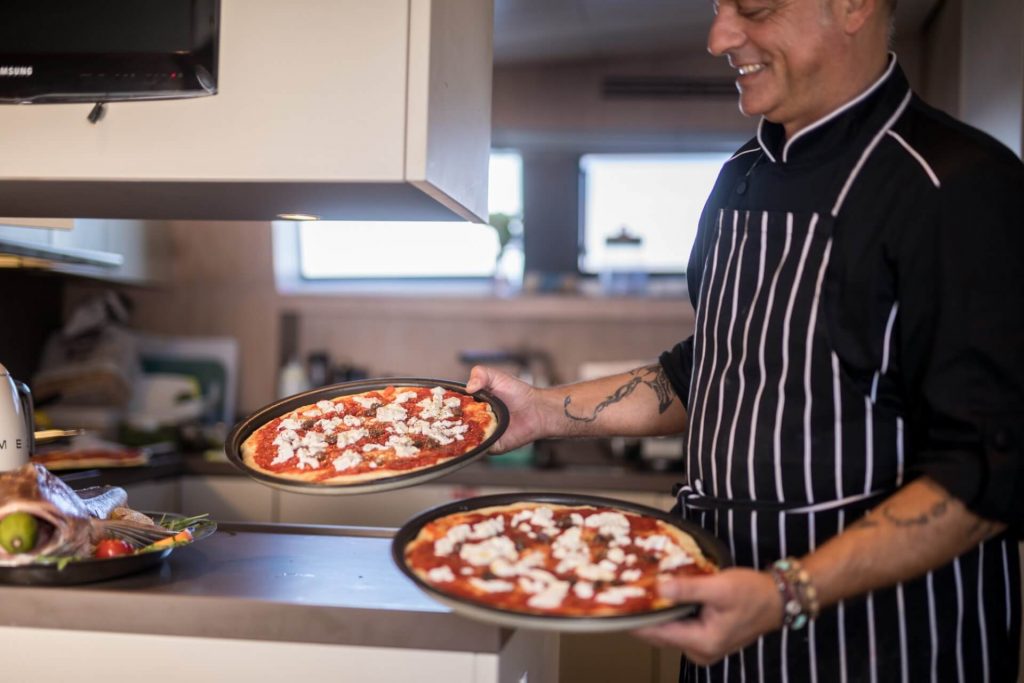 chef is showing two pizzas