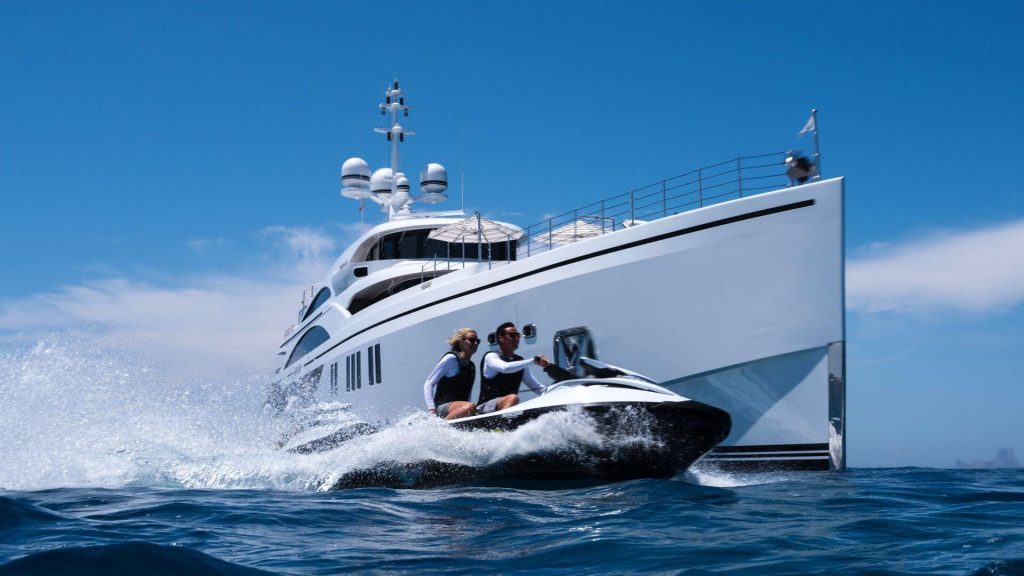 couple on a ski jet by a superyacht