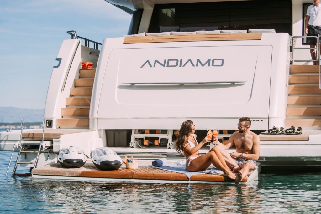 andiamo yacht charter guests with cocktails on swimming platform