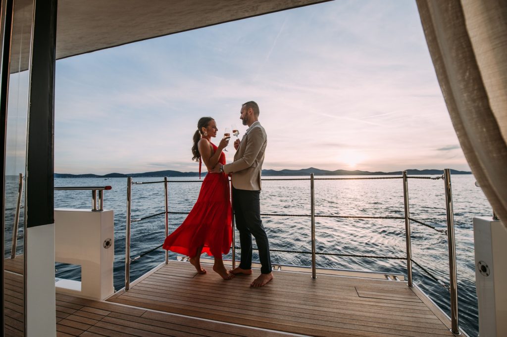 andiamo yacht charter couple with drinks at yacht balcony