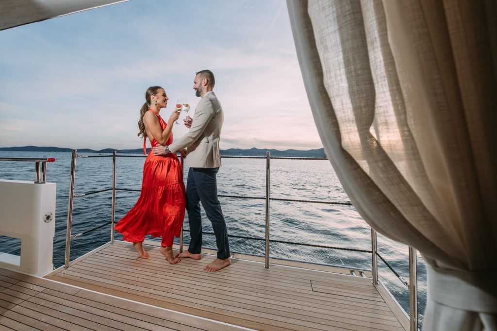 andiamo yacht charter couple standing on the yacht balcony