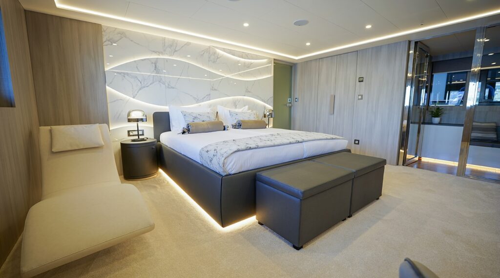 double bed in the yacht master cabin, deck chair next to it