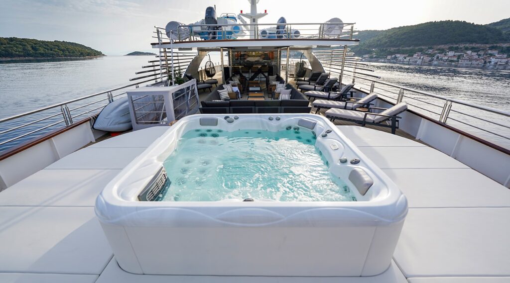 jacuzzi on the yacht surrounded with sun pads, sun loungers & seating area front