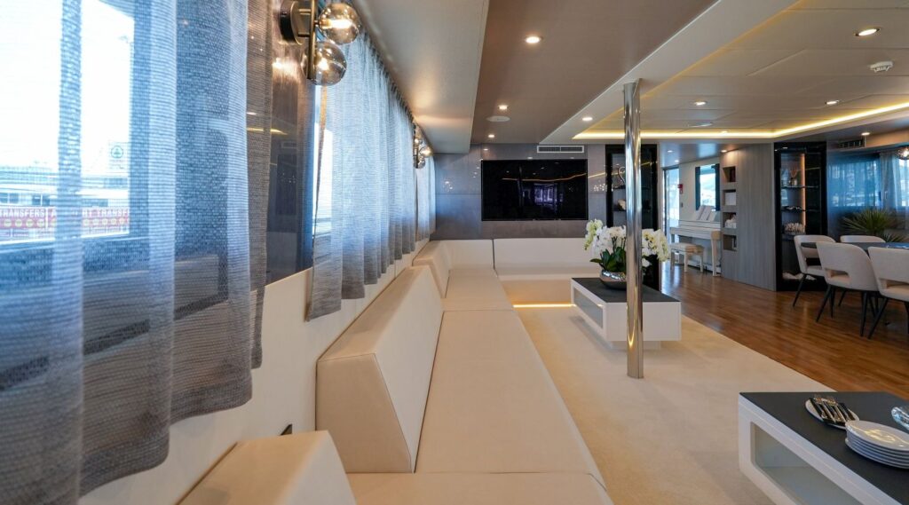 long sofas, coffee tables & a wide screen tv in the yacht salon