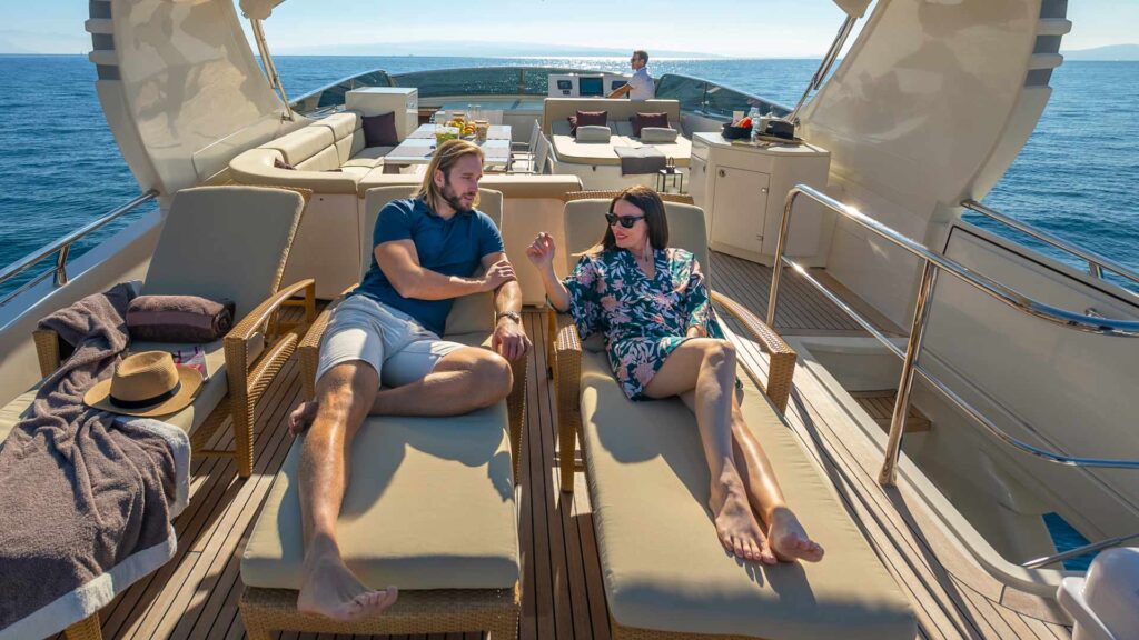 people relaxing on two sun loungers