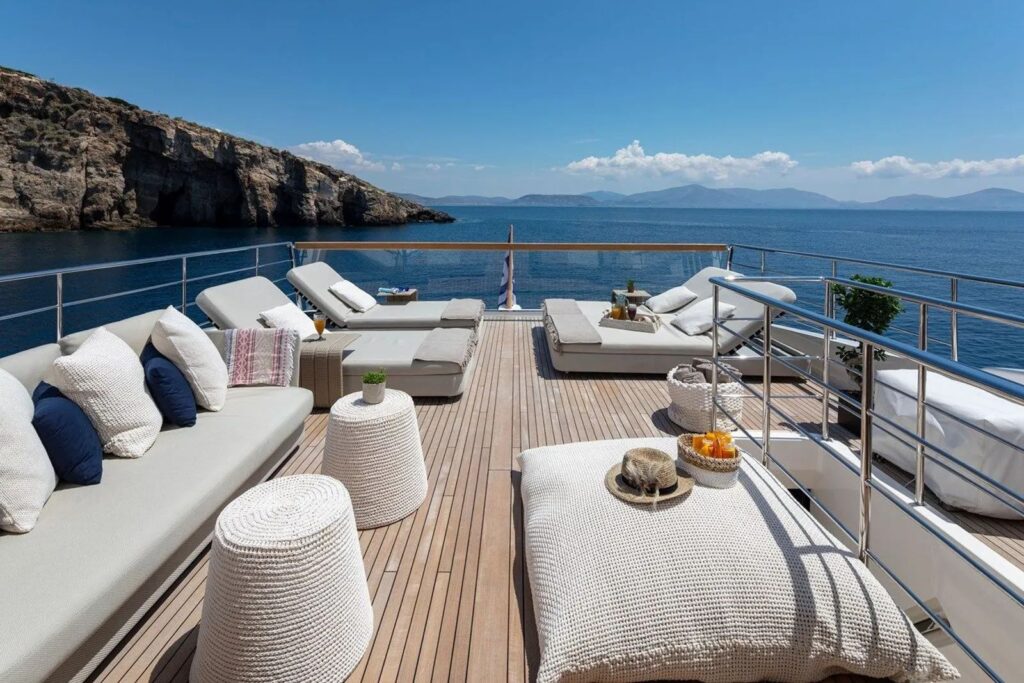 sundeck area with a sofa, coffee tables & sun loungers